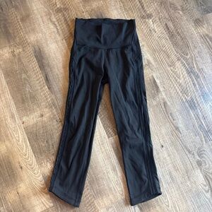 Black Lululemon high-waisted leggings with side lace detailing Capris
